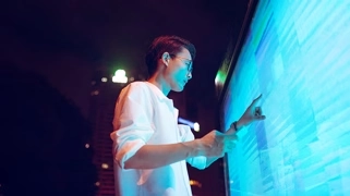 Un homme interagissant avec une interface numérique futuriste, illustrant l'intégration de l'humain et de l'IA