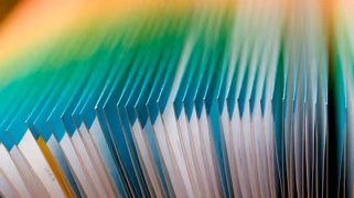 Feuilles de papier colorées en dégradé formant un éventail, symbolisant la planification et l'organisation en IA
